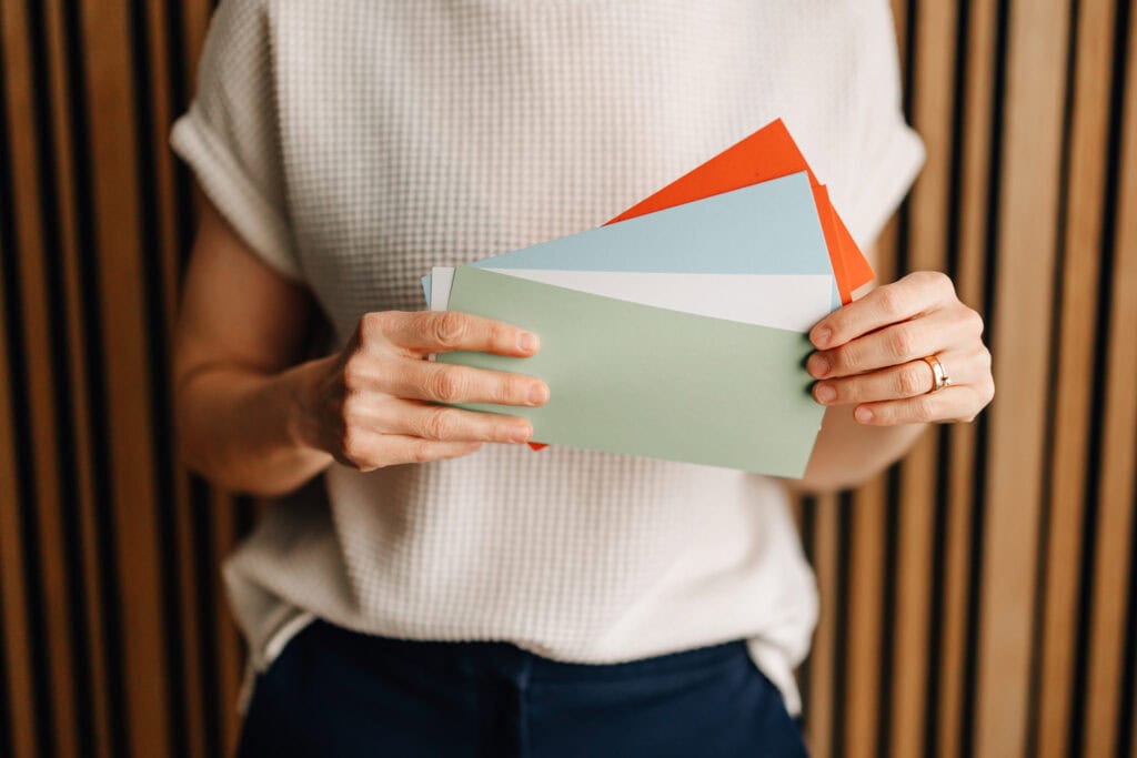 Gesa Zoetler holding colorful paper in front of her