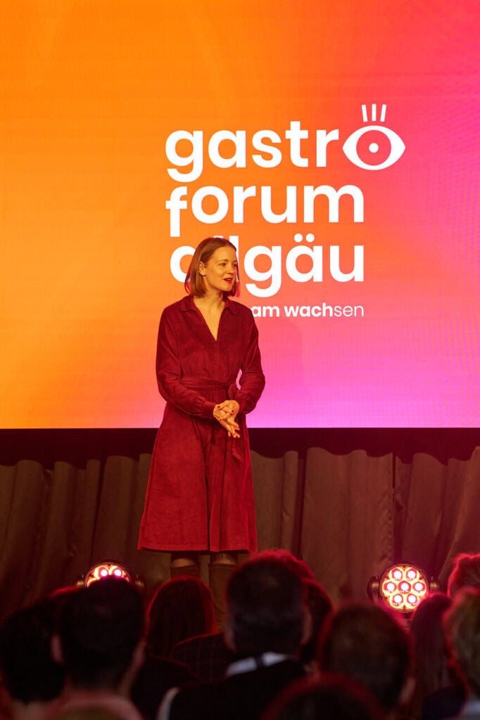 Gesa Zoetler standing on stage at a conference